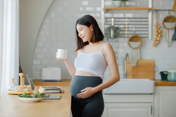pregnancy, healthy food and people concept - close up of happy pregnant woman eating vegetable salad for breakfast in bed at home. Child and Maternity prenatal care concept.