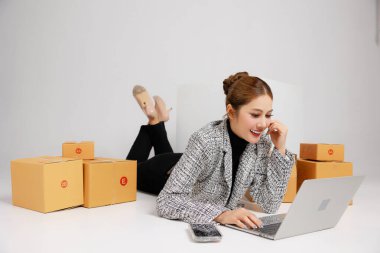 Asyalı akıllı girişimci iş kadını portresi mağazadaki paket kutuları müşteri çevrimiçi pazarlama paketleriyle çevrili. KME kavramı.