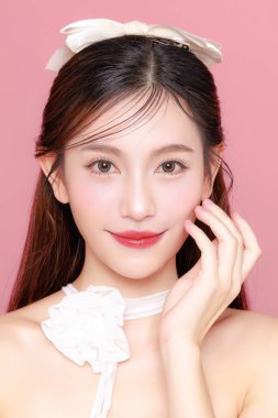 Güzel Asyalı kadın model uzun saç mükemmel temiz ten tebessümü izole pembe arka planda. Portre zarif bayan güzellik blogcusu stüdyoda makyaj sanatçısı. Cilt bakımı, estetik ameliyat, spa konsepti.