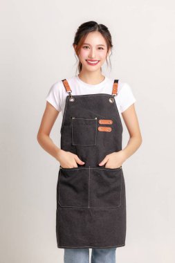 Pişirme önlüğü giyen gülümseyen Asyalı genç bir girişimci yarı zamanlı olarak izole bir arka planda çalışıyordu. Küçük işletme ve başlangıç konsepti.