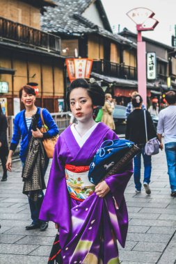 Kyoto Japonya 'da Gion caddesinde yürüyen maiko geyşa. 10 Nisan 2012