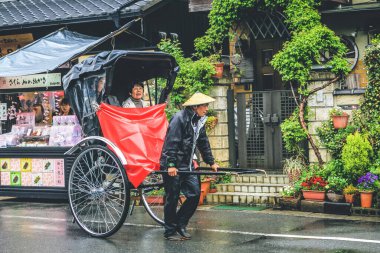 Ziyaretçiler Arashiyama, Kyoto, Japonya 'da triportöre biniyorlar. 11 Nisan 2012