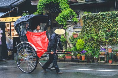Ziyaretçiler Arashiyama, Kyoto, Japonya 'da triportöre biniyorlar. 11 Nisan 2012