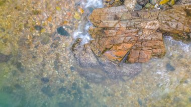 Okyanus kıyısındaki kayalara vuran dalgaların görüntüsü.