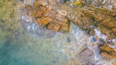 Okyanus kıyısındaki kayalara vuran dalgaların görüntüsü.