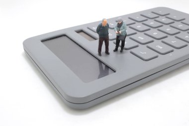 Hesap makinesi olan küçük yaşlı insanlar.