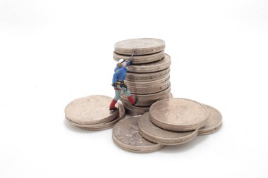 Mini tırmanışçılar bozuk para yığınına tırmanıyor.