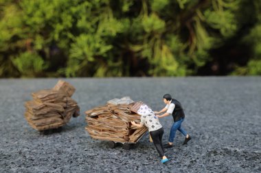 Minik bir figür yük arabasının içinden torba geçirir.