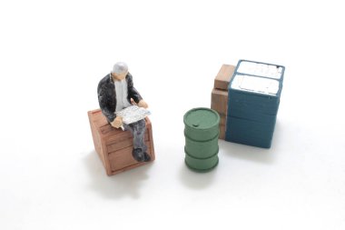 Gazete okuyan bir adam figürü.