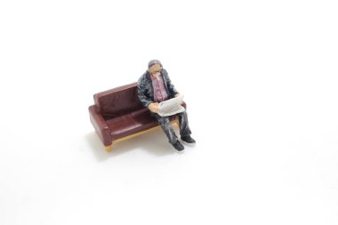 Gazete okuyan bir adam figürü.