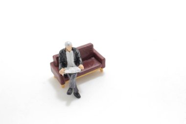 Gazete okuyan bir adam figürü.