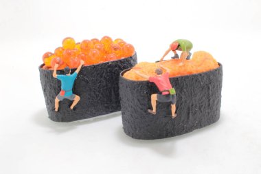 Minik heykelcikler suşiye tırmanıyor.