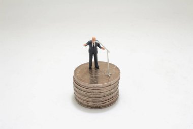 Bozuk para yığınının üzerinde duran bir işadamı. İş konsepti için resim kullanımı