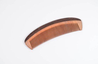 a closeup brown wooden comb on a white background