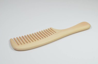 a closeup brown wooden comb on a white background