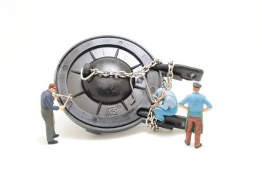 a mini figure of worker repairing toilet,