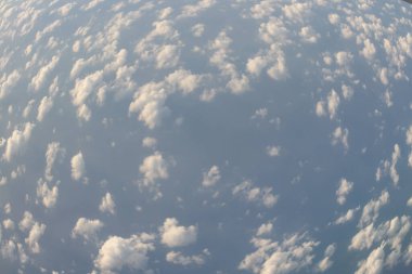 Bulut ve mavi gökyüzü yukarıda uçak penceresinden görünümü