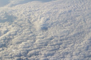 Bulut ve mavi gökyüzü yukarıda uçak penceresinden görünümü