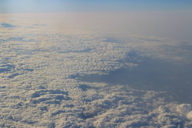 Bulut ve mavi gökyüzü yukarıda uçak penceresinden görünümü
