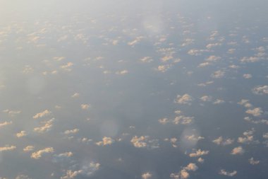 Bulut ve mavi gökyüzü yukarıda uçak penceresinden görünümü