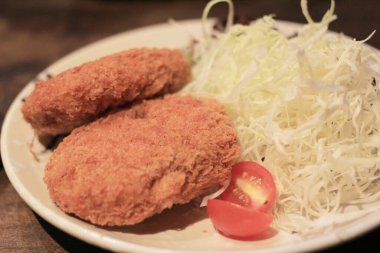 Japanese style deep fried oysters on brown wooden background
