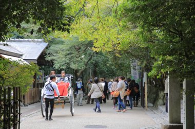 Arashiyama, Kyoto 'da dar bir cadde boyunca seyahat eden bir triportör. 2 Kasım 2013