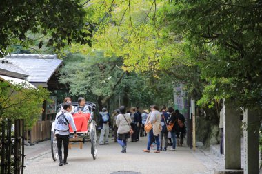 Arashiyama, Kyoto 'da dar bir cadde boyunca seyahat eden bir triportör. 2 Kasım 2013