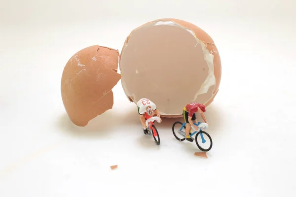 stock image mini figure ride the bike with egg shell