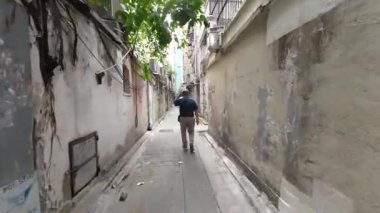 15 Nisan 2023 'te Kowloon, Hong Kong' da yürüyen bir adamın arka görüntüsü.