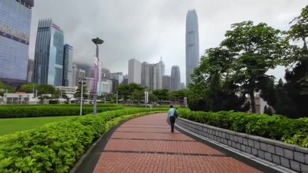 Человек Идущий Аллее Тамар Парк Правительственными Зданиями Гонконга Заднем Плане — стоковое видео