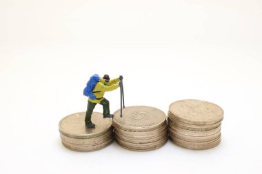 Sırt çantalı yürüyüşçüler bozuk para yığınıyla figürler