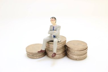 İşadamı oturuyor ve bozuk paraların üzerinde dinleniyor.