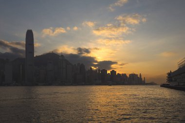 Hong Kong - 08 Aralık 2023: Günbatımında bulutlu gökyüzü altında modern şehir manzarasının manzarası 