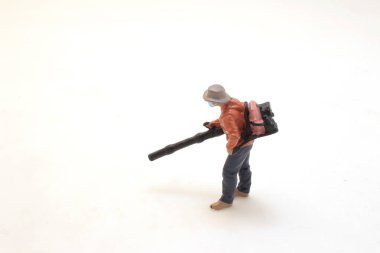 figure removing leaves from footpath in park