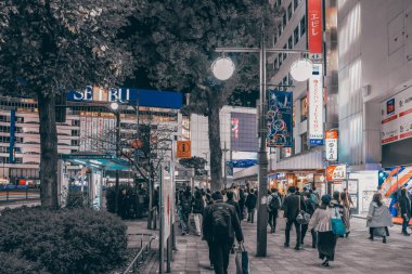 Gökdelenler ve kalabalıkla dolu bir gece sokağı..