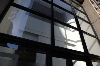 Modern gökdelen mavi cam bir cephede yansıyor. 28 Kasım 2023