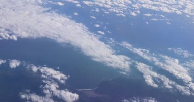 Bir uçak kabininin içinden bulutların ve kanadın görüntüsü