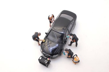 Tamirci araba tamir ediyor, genç adam izliyor.