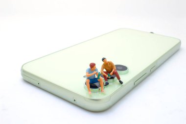 Arkadaşlar cep telefonuyla bira içerken eğleniyorlar.