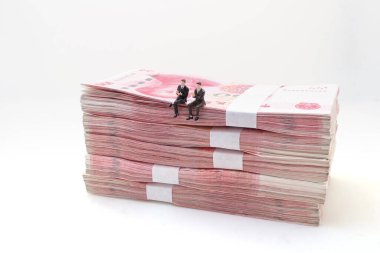 İşadamı Çin Yuan banknotlarının üzerine oturur.