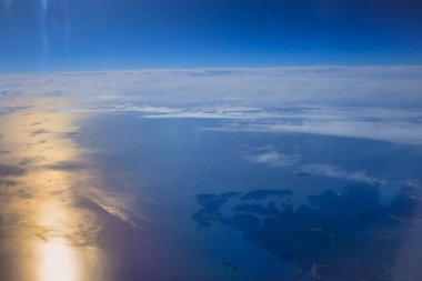 Uçak penceresinden bak. Su yüzeyindeki bulutlar.