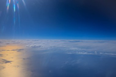 Uçak penceresinden bak. Su yüzeyindeki bulutlar.