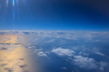 Uçak penceresinden bak. Su yüzeyindeki bulutlar.