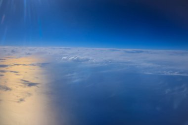 Uçak penceresinden bak. Su yüzeyindeki bulutlar.