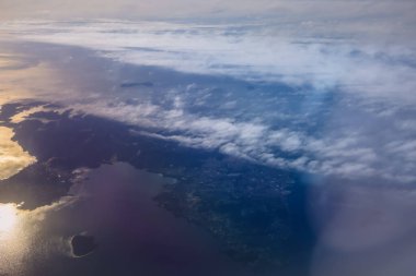 Uçak penceresinden bak. Su yüzeyindeki bulutlar. Atmosfer kavramı