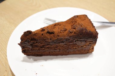 Beyaz tabakta siyah çikolatalı pasta.