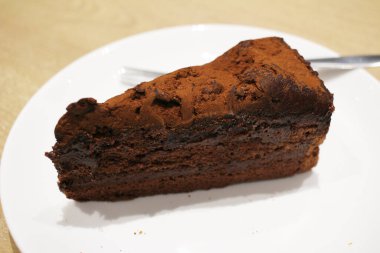 Beyaz tabakta siyah çikolatalı pasta.