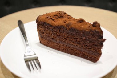 Beyaz tabakta siyah çikolatalı pasta.