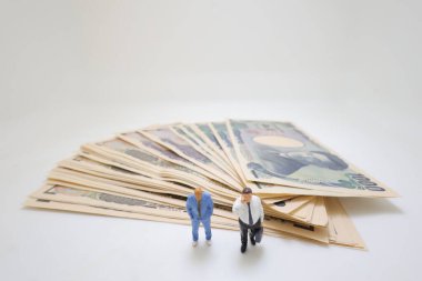 Durgunluk konsepti. Para yığını üzerinde duran iş adamları