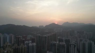 Hong Kong - 2 Haziran 2024: Bulutlu gökyüzü altındaki muhteşem şehir manzarası, gün batımı zamanı 